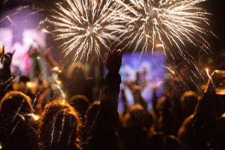 new Year concept - cheering crowd and fireworksの写真素材