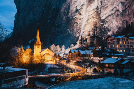amazing touristic alpine village at night in winter with famous church and Staubbach waterfall  Lauterbrunnen  Switzerland  Europeの写真素材
