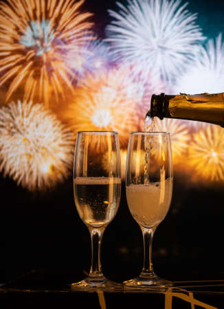 two champagne glasses against fireworks  New Year's eve celebrationの写真素材