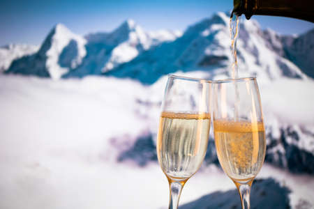champagne glasses  and snowy peaks in background  New Yearの写真素材