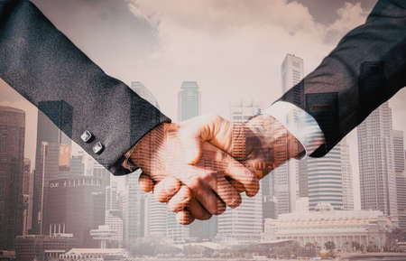 business collaboration double exposure of handshake and modern cityの写真素材
