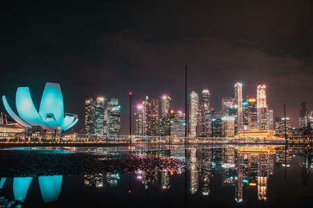 SINGAPORE, SINGAPORE - MARCH 2019: Skyline of Singapore Marina Bay at night with Marina Bay sands, Art Science museum , skyscrapers and tourist boatsのeditorial素材
