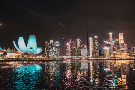 SINGAPORE, SINGAPORE - MARCH 2019: Skyline of Singapore Marina Bay at night with Marina Bay sands, Art Science museum , skyscrapers and tourist boatsのeditorial素材