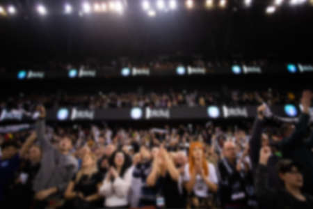 blurred background of supporters at sports event crowd of people in a basketball courtの写真素材