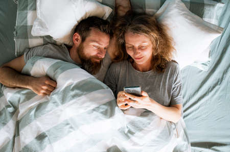 happy couple in bed healthy relationshipの写真素材