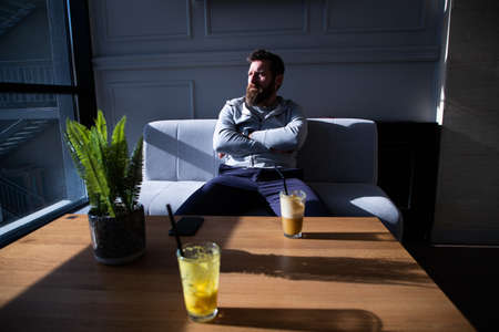 man on a terrace drinking orange  fresh on a sunny dayの写真素材