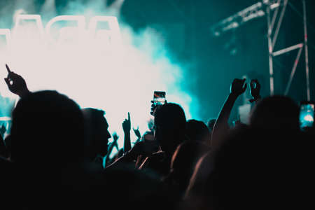 cheering crowd with raised hands at concert - music festivalの写真素材