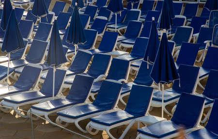 beach chairs and umbrellas near a poolの写真素材