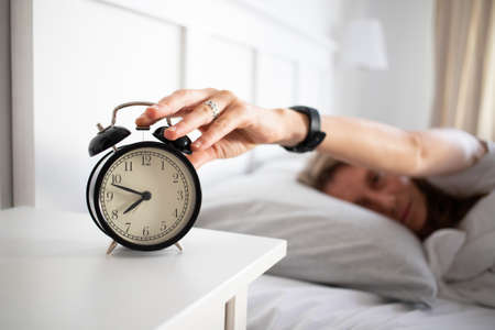 alarm clock and woman sleeping in bed sleep quality