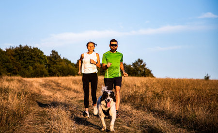 fit couple running with dogの写真素材