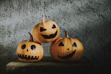 scary funny Halloween pumpkins on wooden tableの写真素材