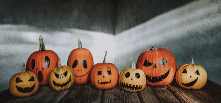 scary funny Halloween pumpkins on wooden tableの写真素材
