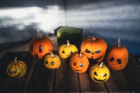 scary funny Halloween pumpkins on wooden tableの写真素材