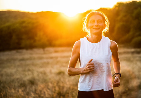fit woman running at sunsetの写真素材