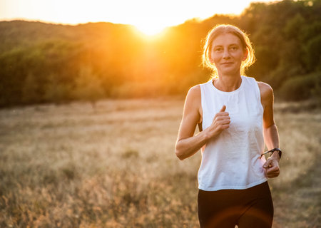 fit woman running at sunsetの写真素材