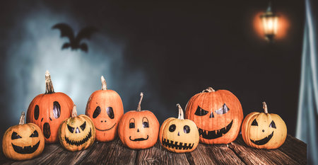 scary funny Halloween pumpkins on wooden tableの写真素材