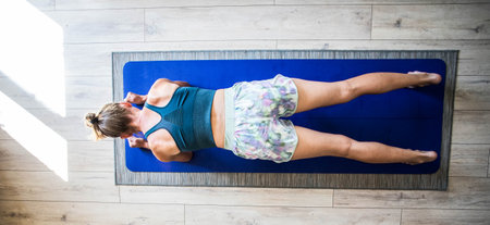 top view of woman doing yoga on matの写真素材