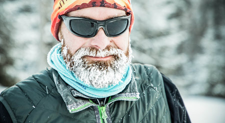 trail runner with frozen beard training in winter landscape