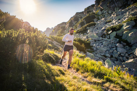 trail runner running in mountain landscape at sunset active lifestyleの写真素材