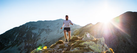 trail runner running in mountain landscape at sunset active lifestyle