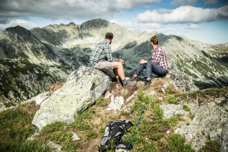 couple sitting on mountain top in amazing summer landscapeの写真素材