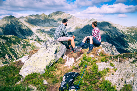 couple sitting on mountain top in amazing summer landscapeの写真素材