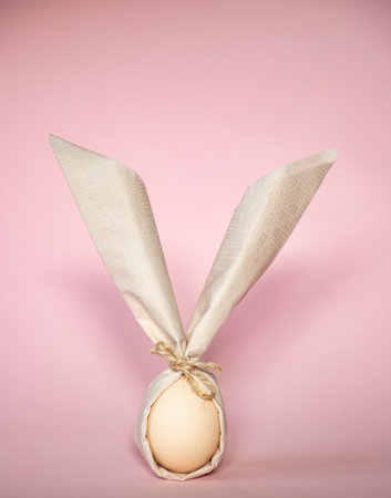 egg wrapped in easter bunny shaped napkinの写真素材