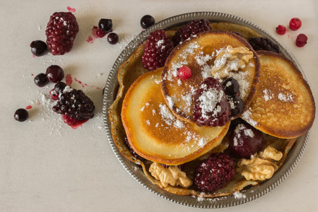Homemade pancakes with berries and walnuts. Concept - healthy breakfast.