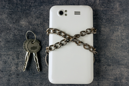 Modern mobile phone and a chain with keys. The concept of information security. Social network, forgot password, piracy.の写真素材