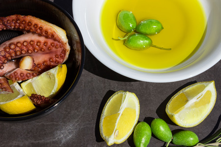 Baked octopus. Traditional Greek snacks. Lemon slices and olives.の写真素材