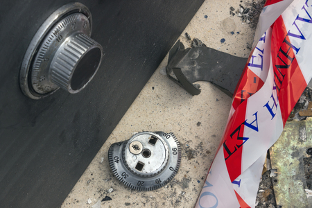 Broken combination lock on the safe closeup. Police tape.  Concept -  burglary, robbery,  crime.のeditorial素材