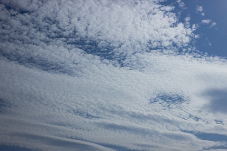 Fluffy white clouds on a blue sky. Clear sunny day. Background.