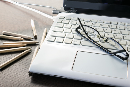 Laptop keyboard, pencil and black glasses. Business concept. Selective focus. の写真素材