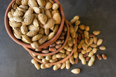 Assortment of nuts in their shell. Different kinds of nuts in  bowls. Healthy food. Selective focus.の写真素材