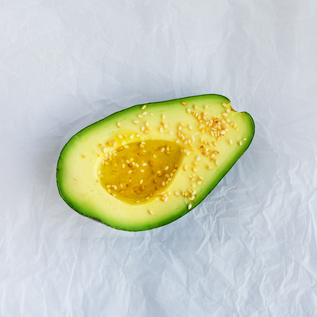 Ripe avocado  on parchment paper. Concept- healthy food, vegetarianism, raw food, a source vitamin...