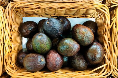 Ripe avocado fruit in a wicker basket.  Concept- healthy food, vegetarianism, raw food, a source...