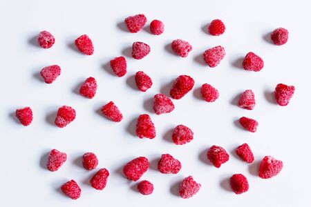 Delicious frozen raspberries are scattered on the white surface. Concept of healthy eating, vegetarianism.の写真素材