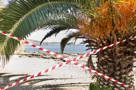 Barrier tape - quarantine, entry ban.  virus Concept of  pandemic and travel. View of the beach...