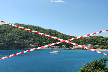 Barrier tape - quarantine, entry ban.  virus Concept of  pandemic and travel. View of the bay with a...