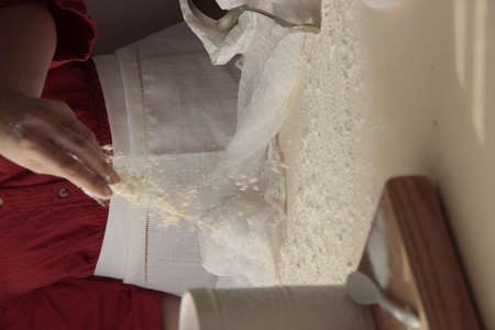 Woman with red dress making bread with flour spreding