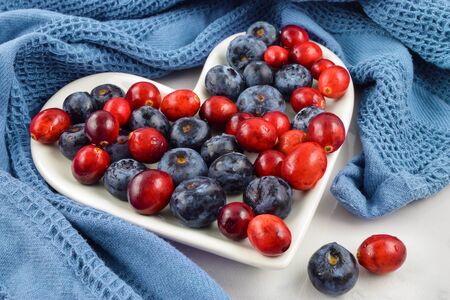 Heart healthy cranberries and blueberries adorn a heart shaped plate encircled by a blue kitchen towel. Great for Independence Day, Memorial Day and Veteran's Day.の写真素材