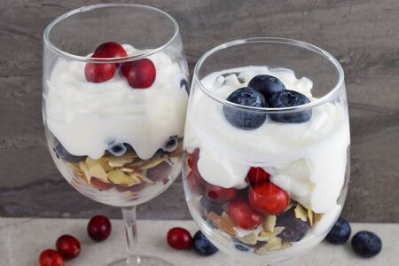 Wineglass parfaits feature fresh red cranberries layered with fresh blueberries, yogurt and sliced almonds. A tasty patriotic dessert.の写真素材