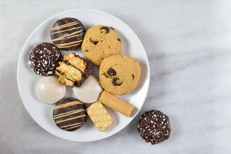 Delicious fresh baked cookies sit merrily on a simple white plate atop a clean marble background. Room for copy.の写真素材