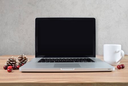 Modern laptop with coffee mug, pine cones and cranberries for a Scandinavian Christmas feel. Has clipping path on inside of screen.の写真素材