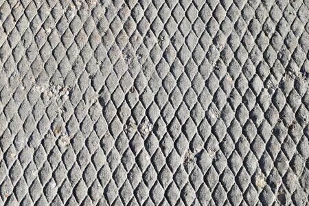 Weathered and aged sidewalk concrete with a diamond patterned texture.の写真素材