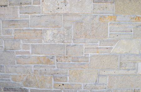 Ancient weathered gray and brown stone wall.の写真素材