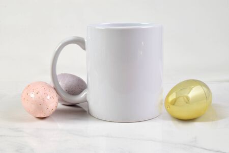 This Easter inspired mock up features an 11 ounce coffee mug surrounded by gold, pink and purple Easter eggs.の写真素材