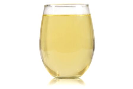 Stemless wine glass filled with white wine resting luxuriously on a white background.の写真素材