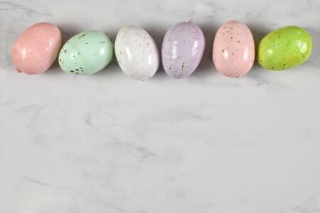 Top down view of colorful speckled Easter eggs on a marbleの写真素材
