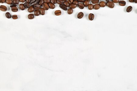 French Vanilla Coffee Beans Scattered on a White Marbleの写真素材